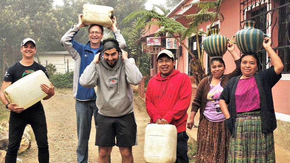 一群全球最大体育平台帮助危地马拉的玛雅村民把水罐搬回家
